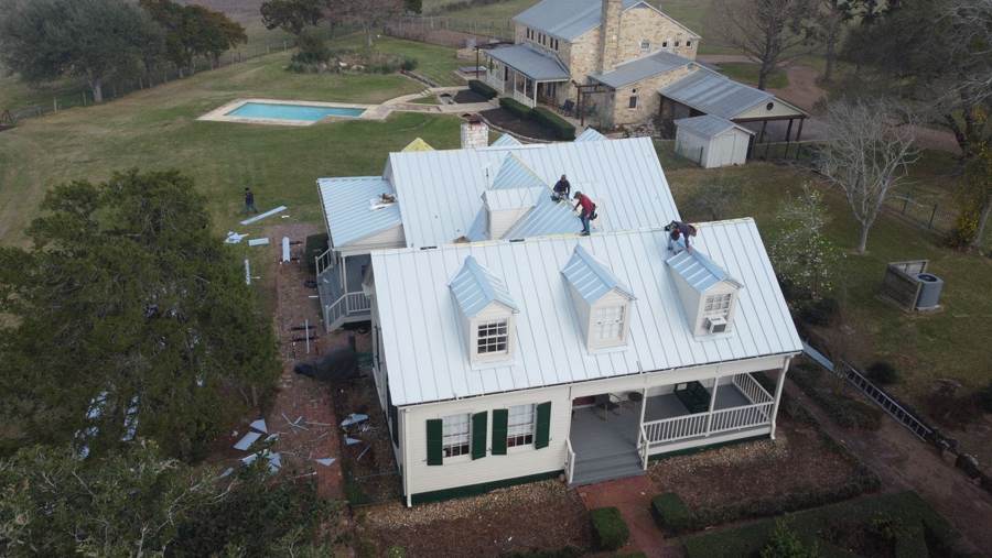 Superior crew installing a standing seam metal roof with dormers