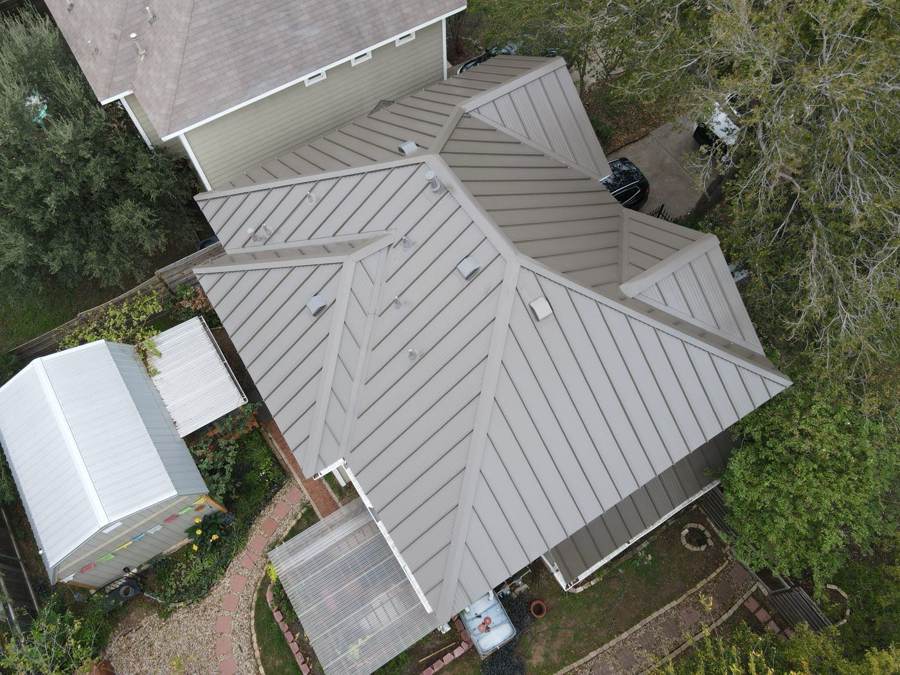 Top-down view of a tan standing seam roof on a home