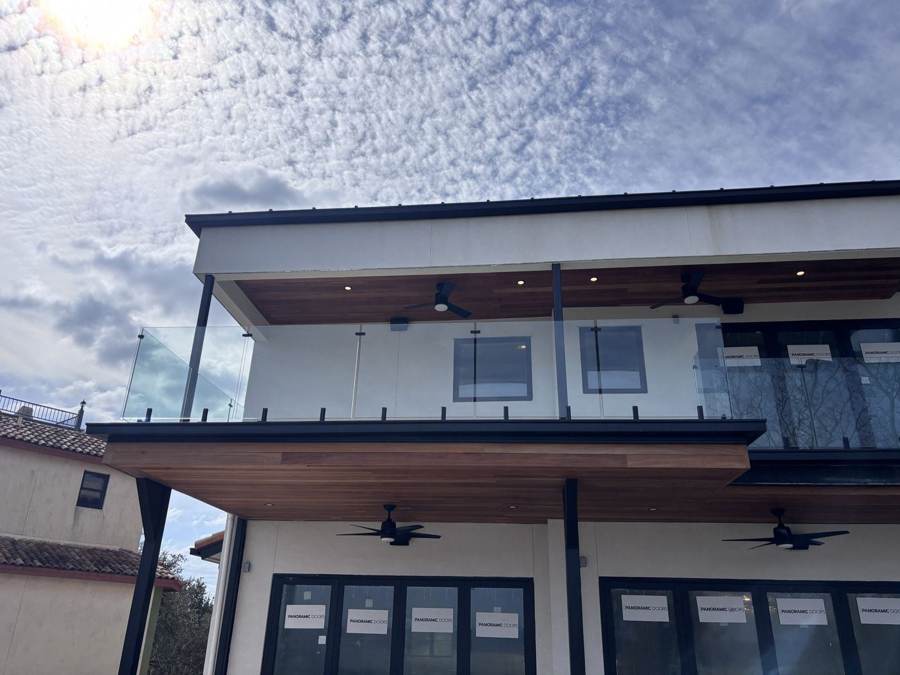 Modern balcony with glass railing and wood soffit